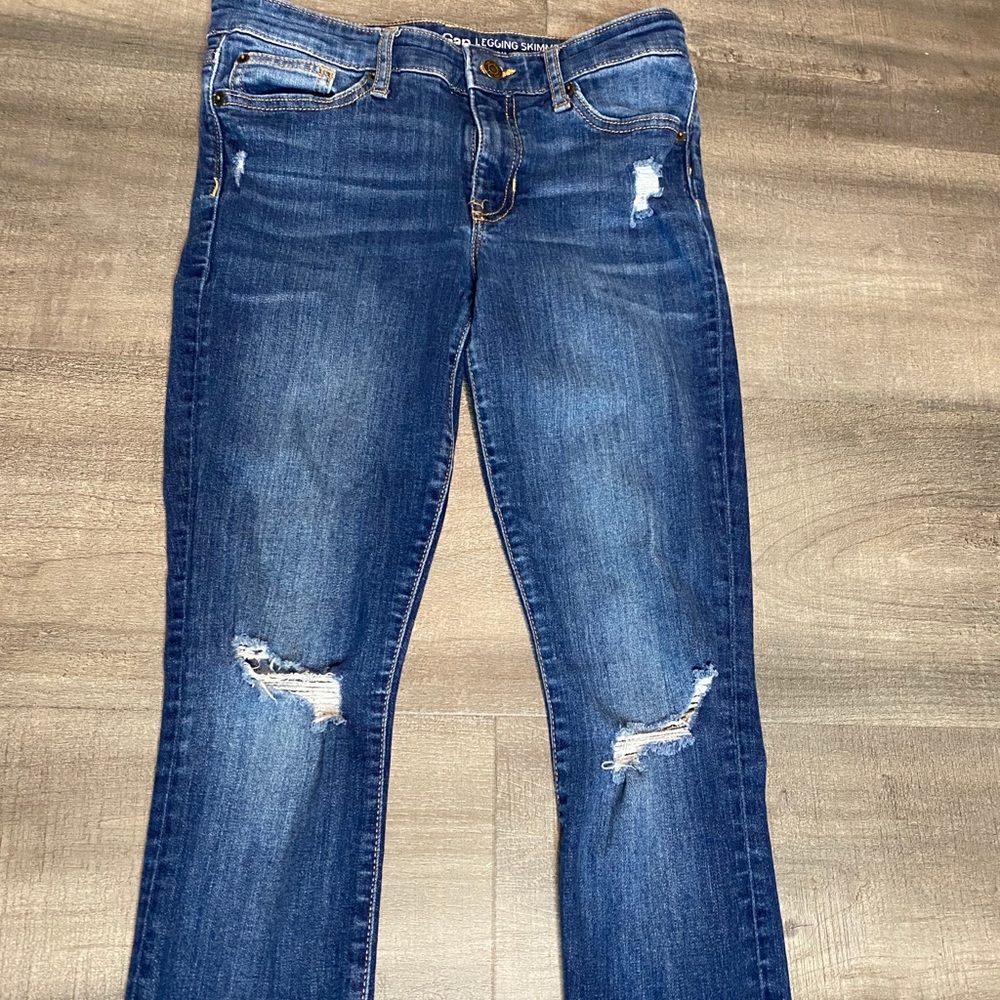 Blue skinny jean with rips in the knees.